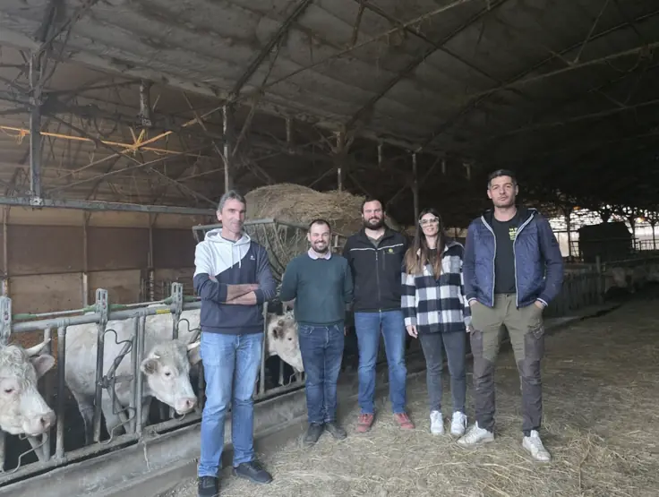 Article du Dauphiné libéré du 12 mars 2026 : cinq agriculteurs d’AGRIS A7 posent dans une stabulation