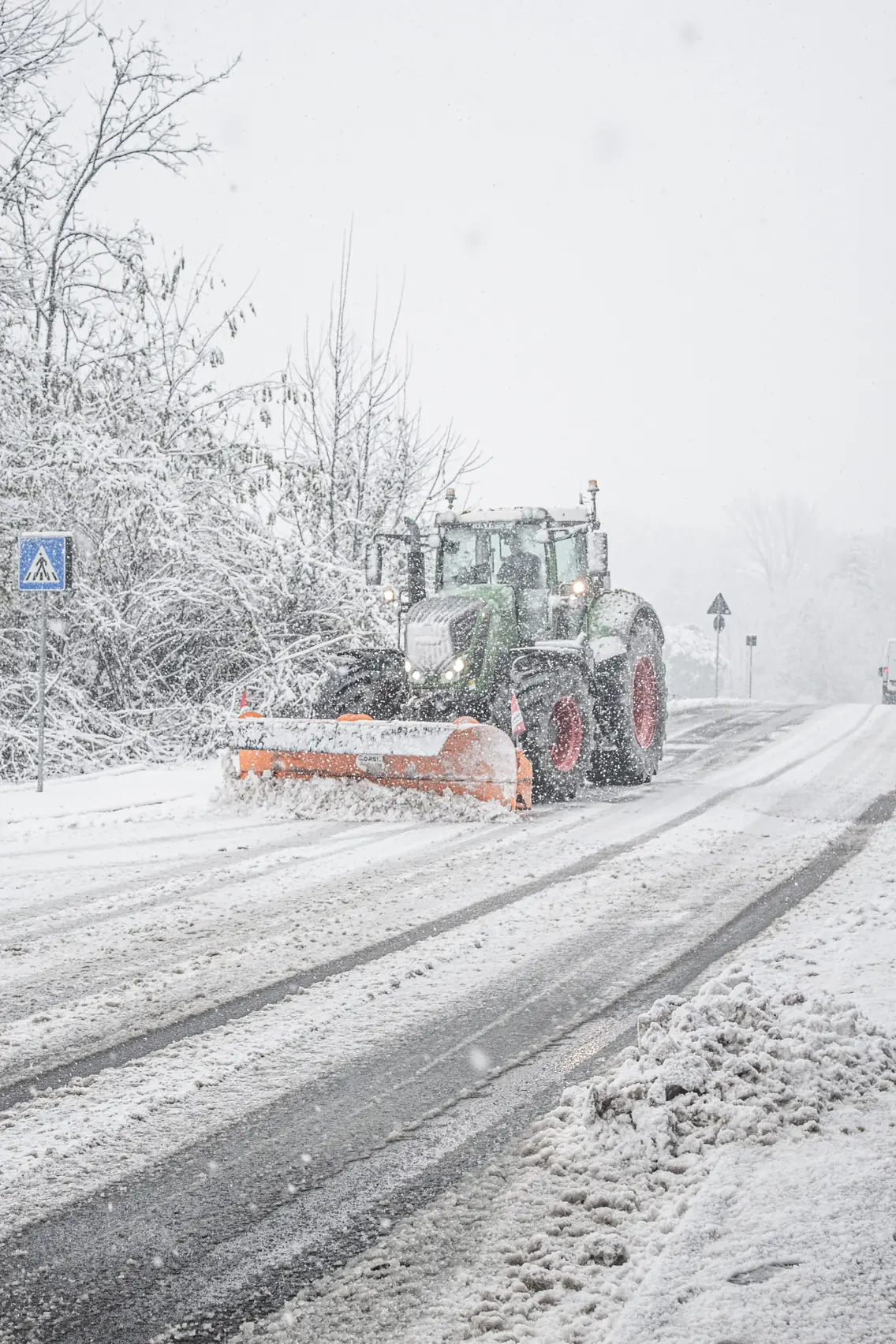 Tracteur équipé d’une lame chasse-neige sur une route enneigée