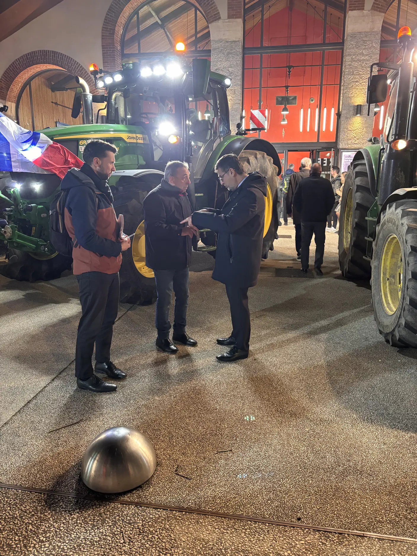 Agriculteurs réunis autour des tracteurs, de nuit, lors de la mobilisation à Vienne